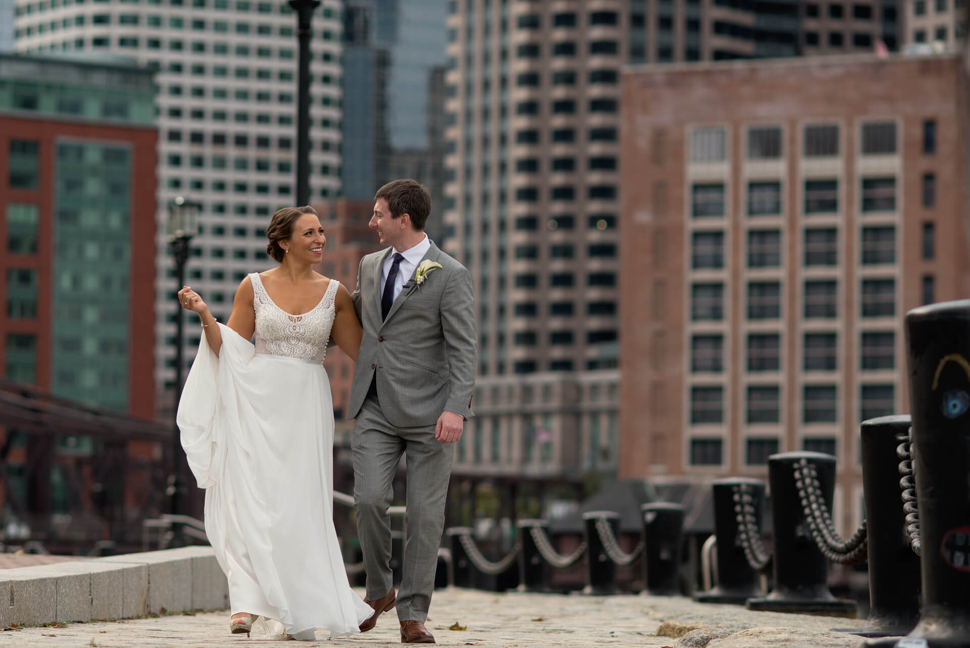 couple walking along fan pier boston before their state room wedding