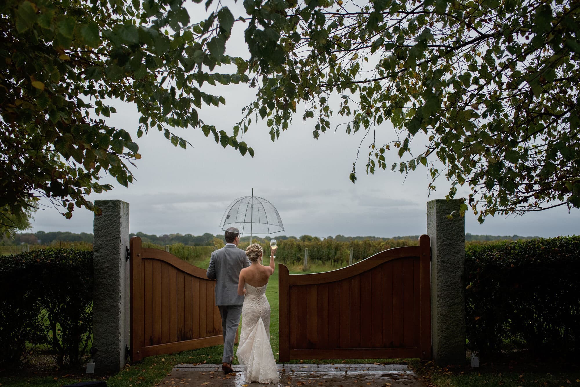 couple walking through gate at saltwater farm vineyard wedding