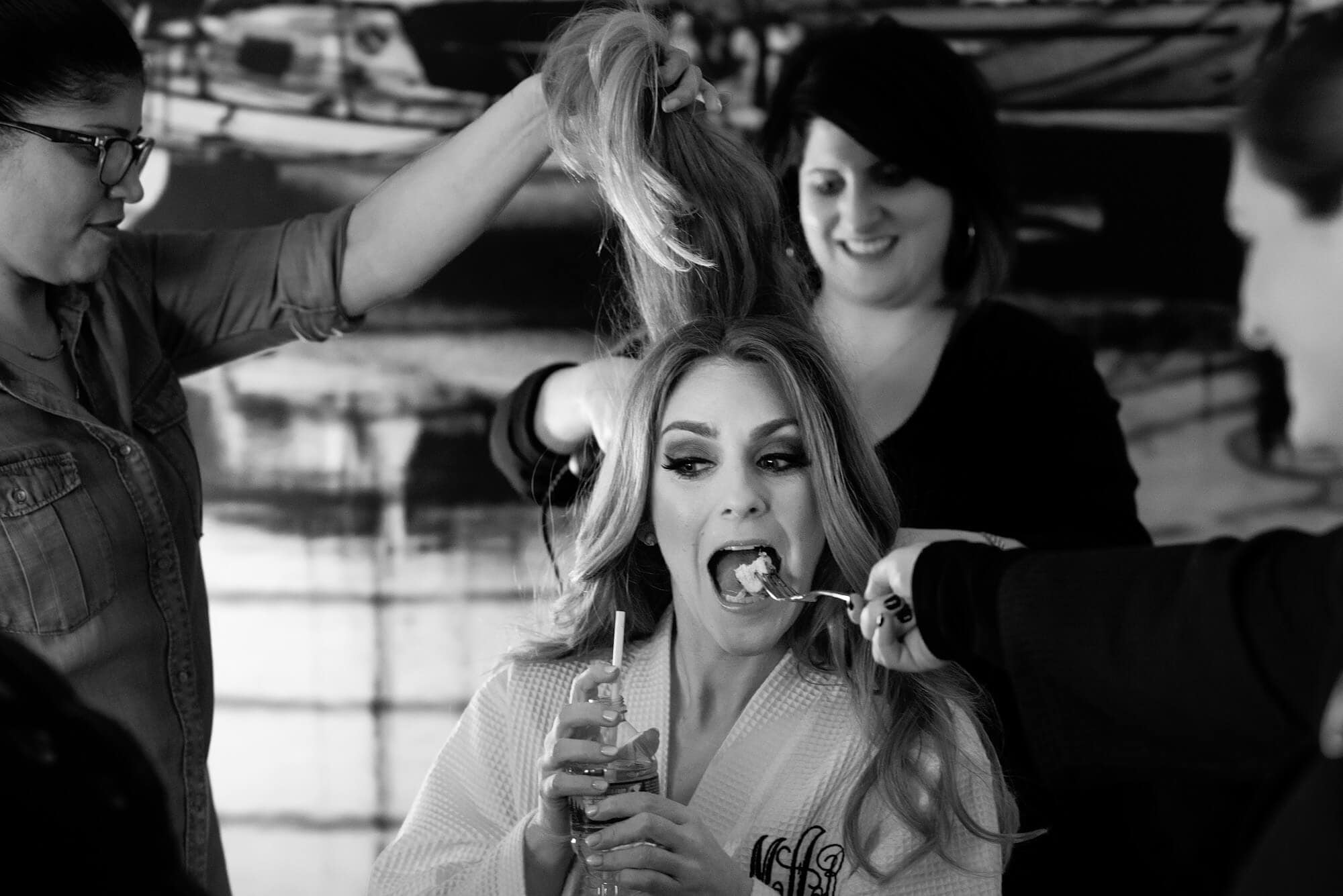 bride being fed during hair and makeup
