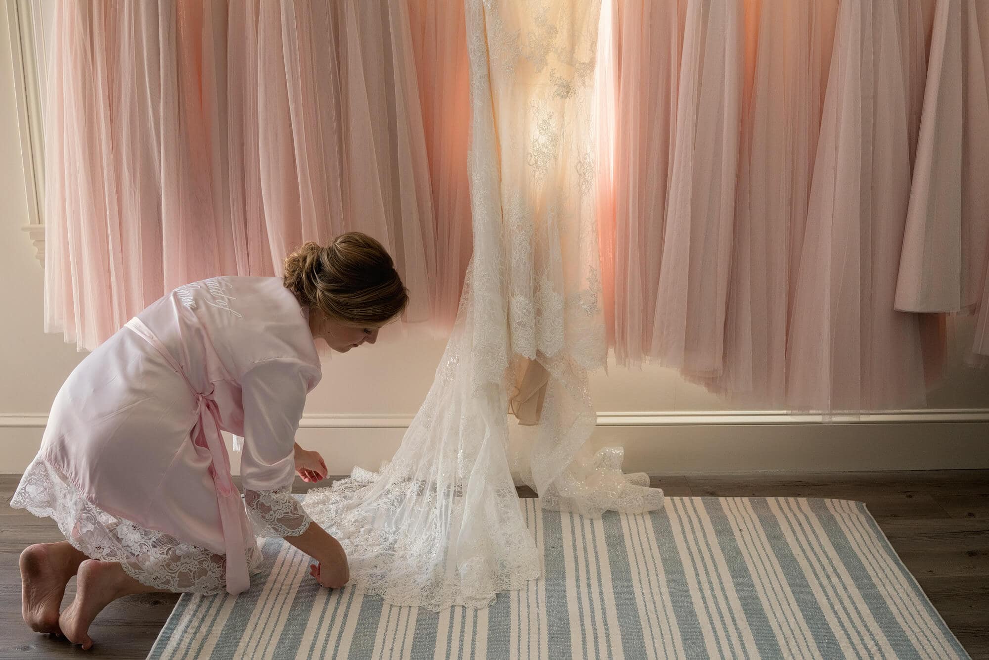 bridesmaid preparing wedding dress for photo