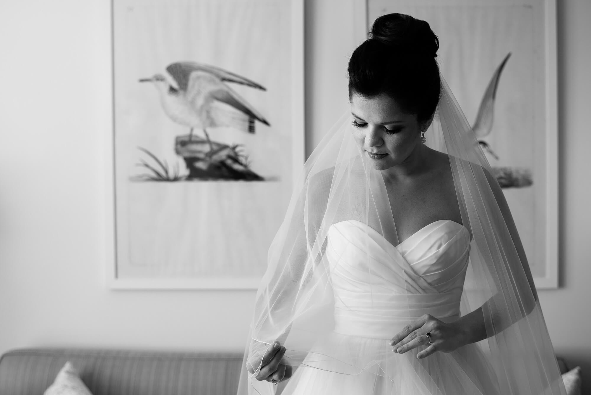 bride taking a moment before ceremony playing with veil