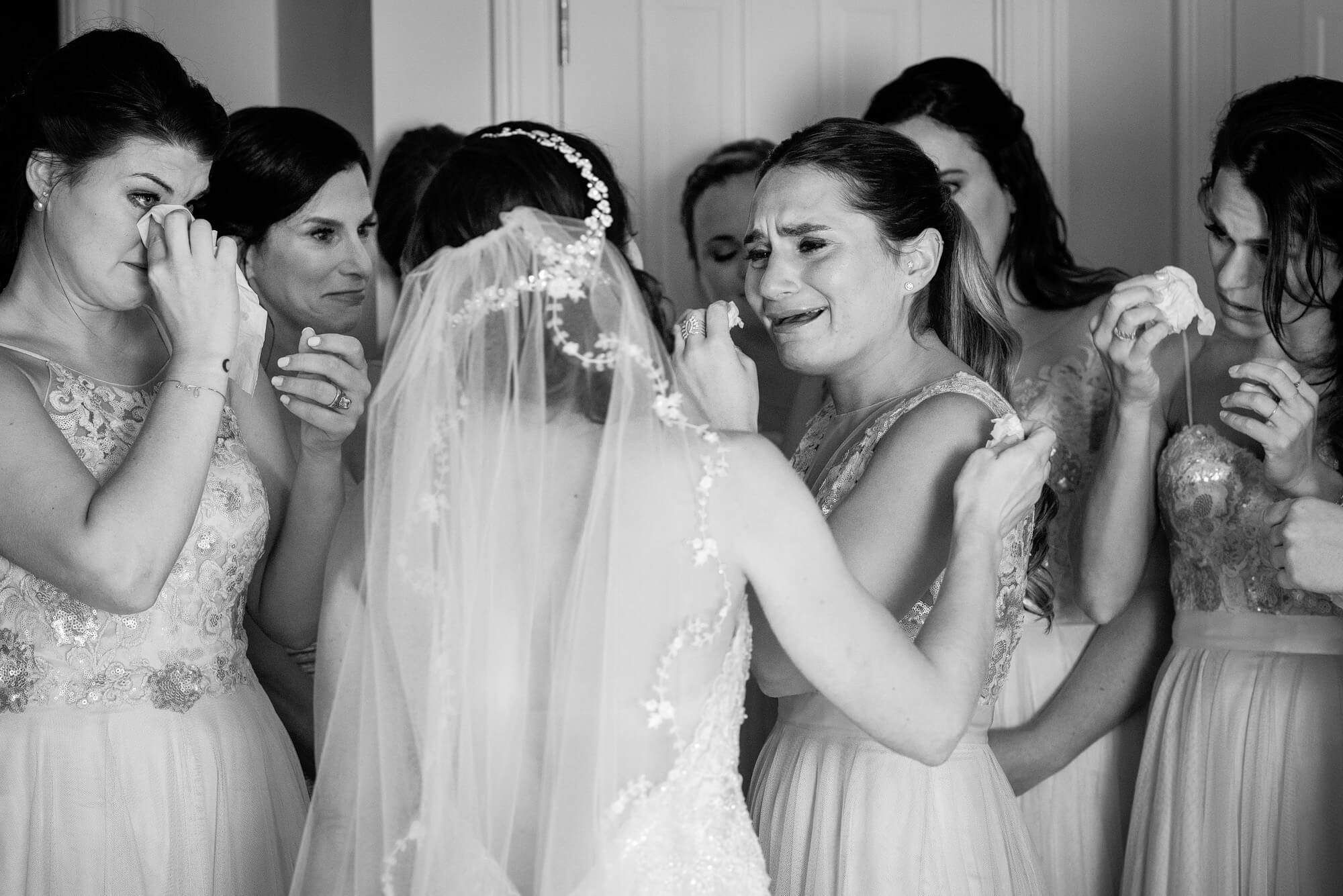 emotional bride and bridesmaids crying together before ceremony