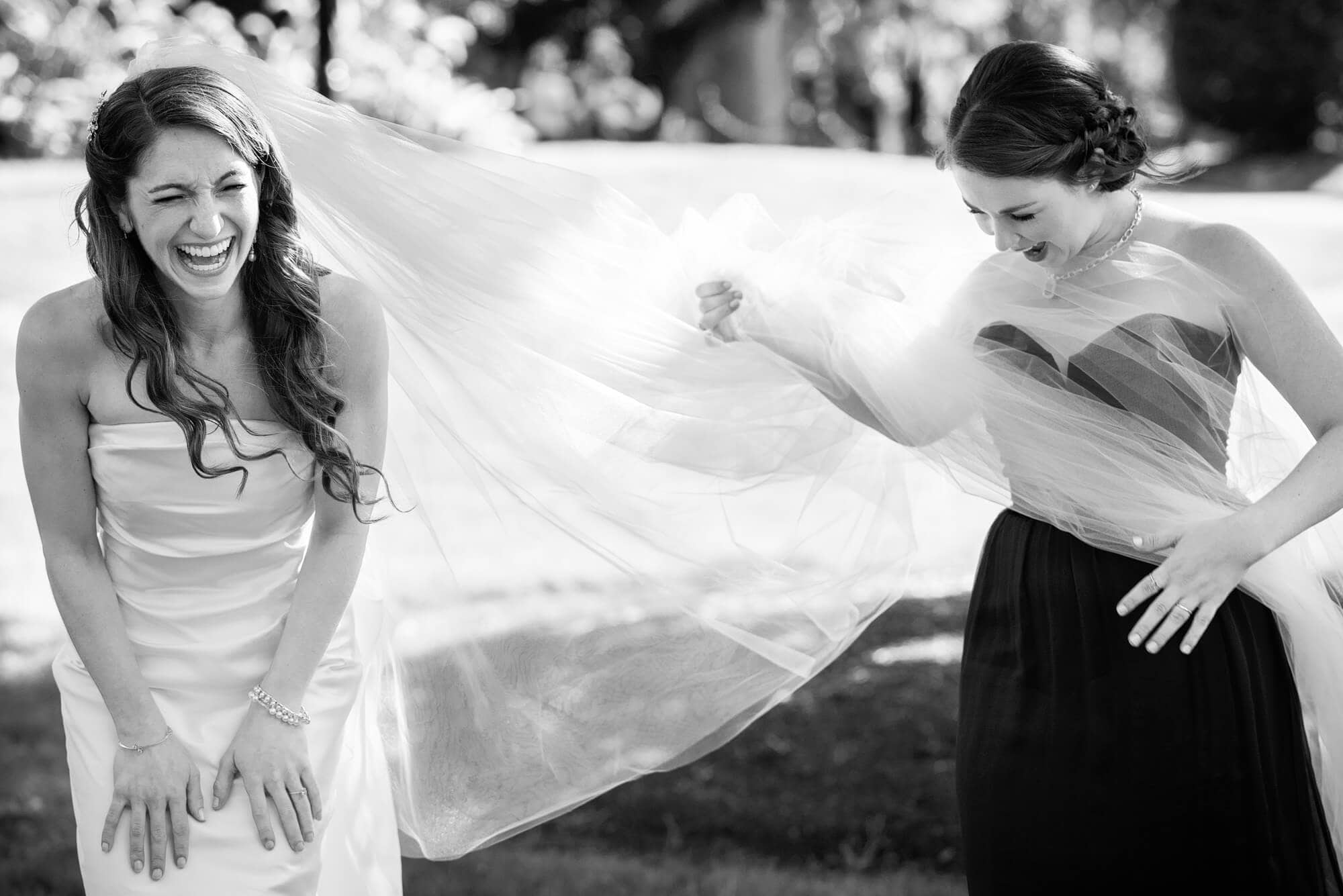 bride laughing as weil catches in the wind
