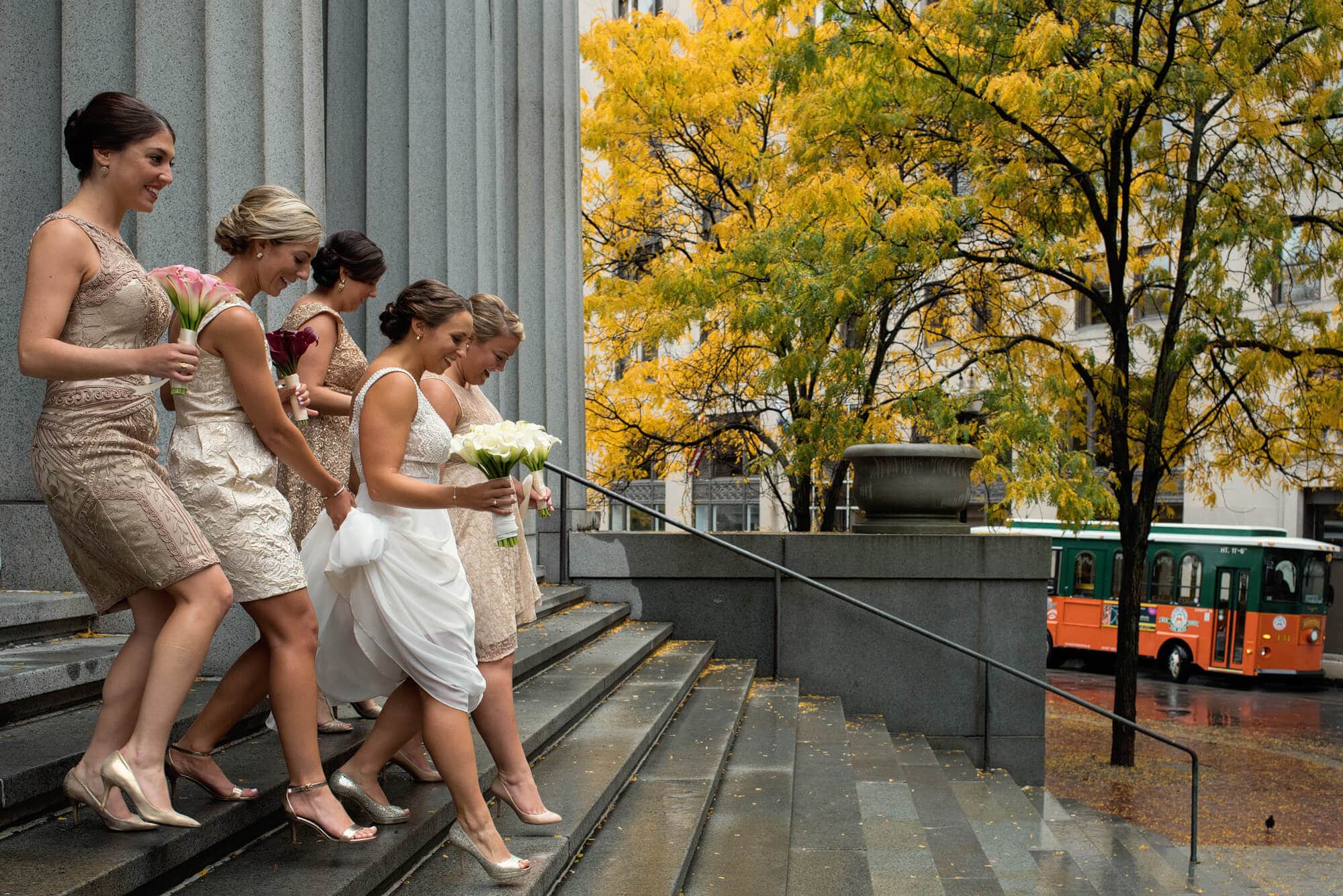 bridesmaids walking in sync down the steps of the church
