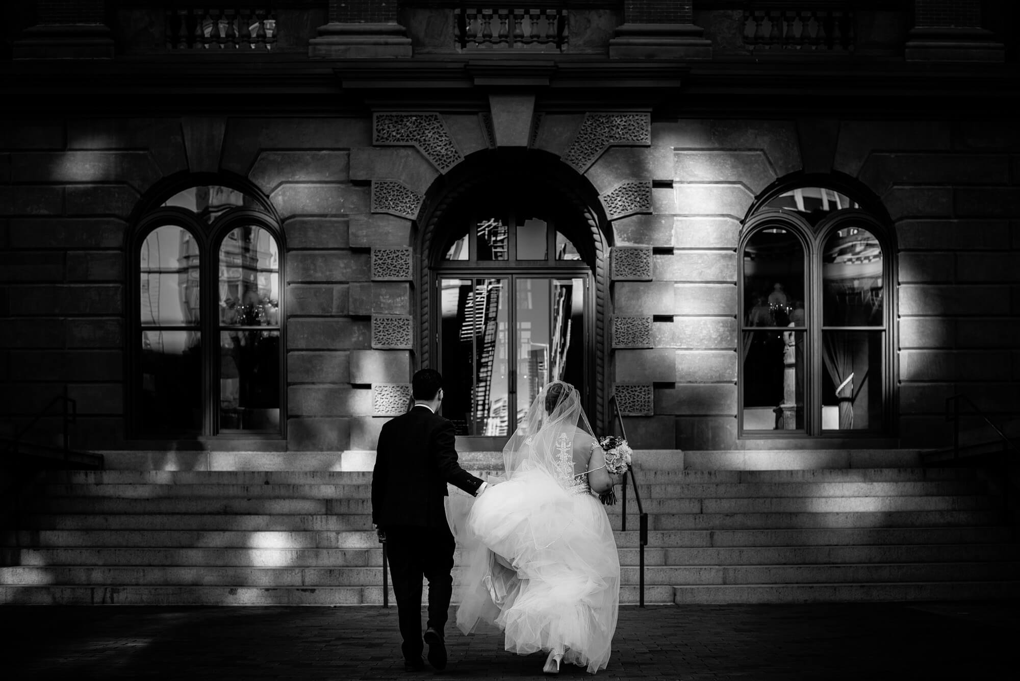 bride and groom classic black and white moment walking through downtown boston