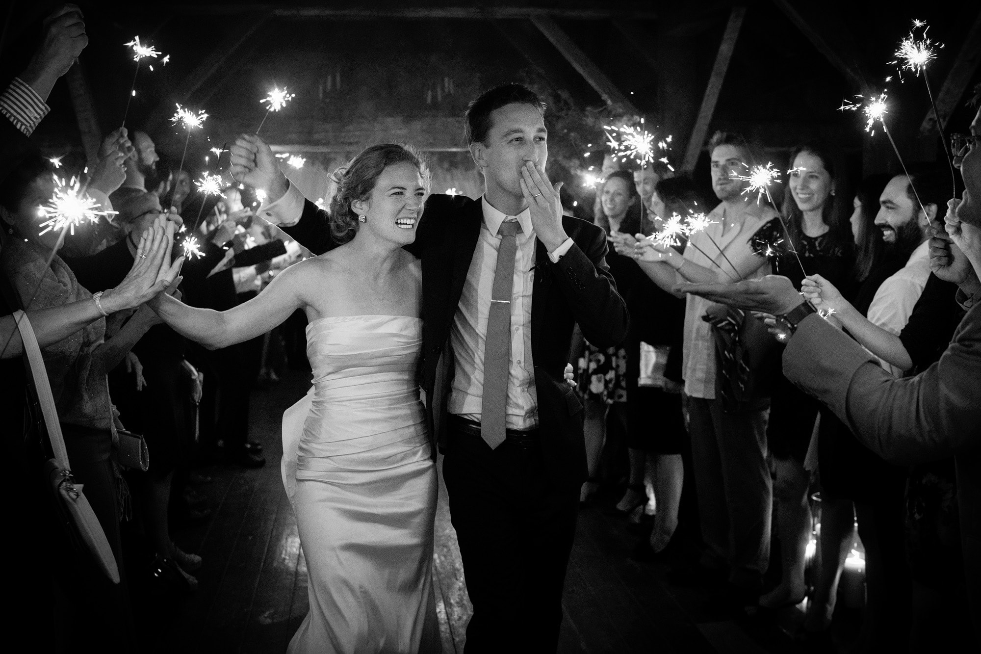 photo of a couple exiting their wedding venue Riverside Farm with a sparkler exit. Taken by the incredible Sony A9 camera, possibly the best wedding photography camera in the world