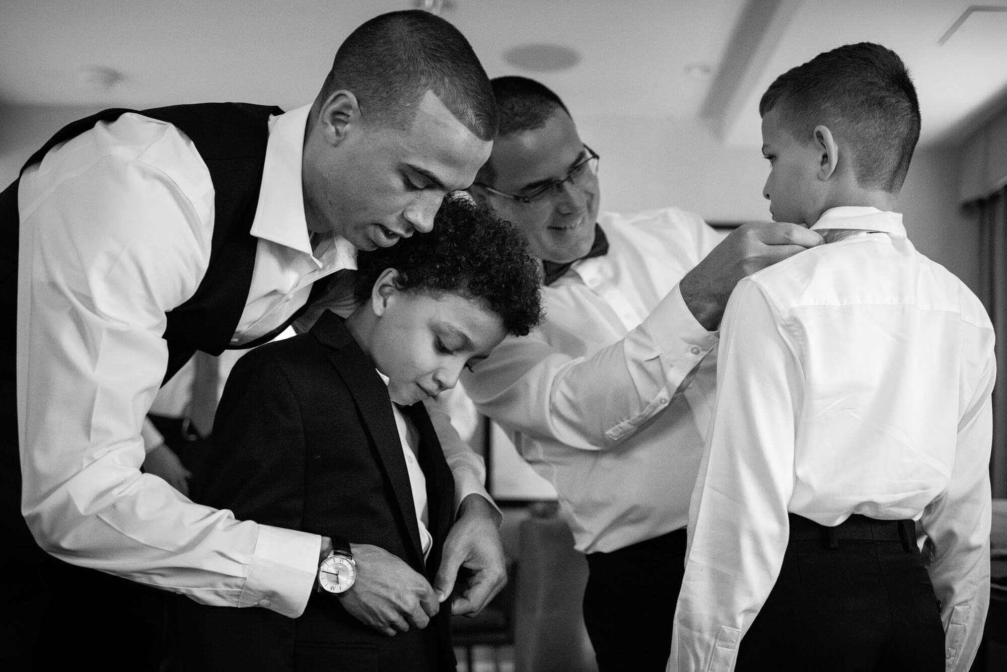 groom helping ring bearers into tiny suits - groom getting ready photos