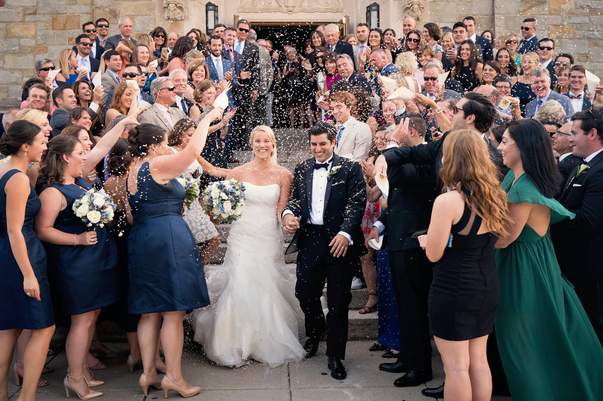 couple leaving church with confetti toss at St Ignatius on the BC campus