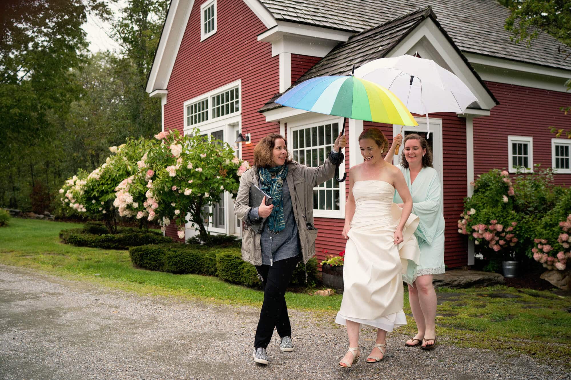 bride heads to first look under umbrella on a rain wedding day