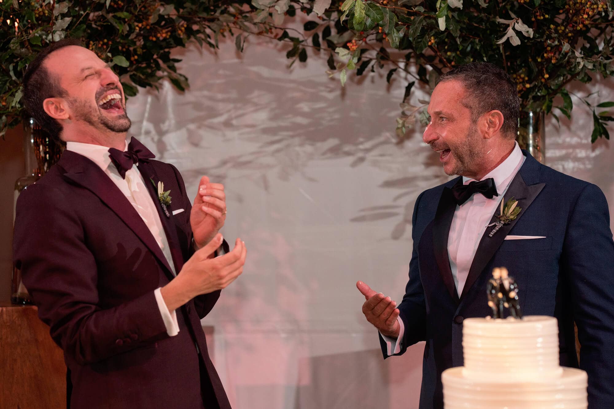 funny cake cutting moment for two grooms at provincetown pilgrim monument wedding