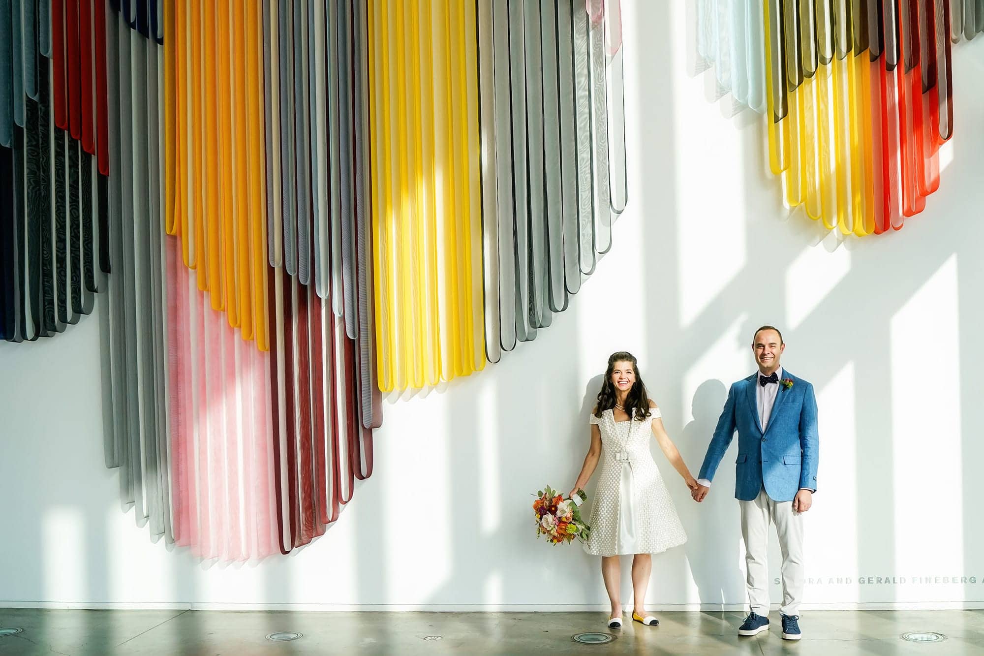 couple at their ICA Boston wedding standing under art installation