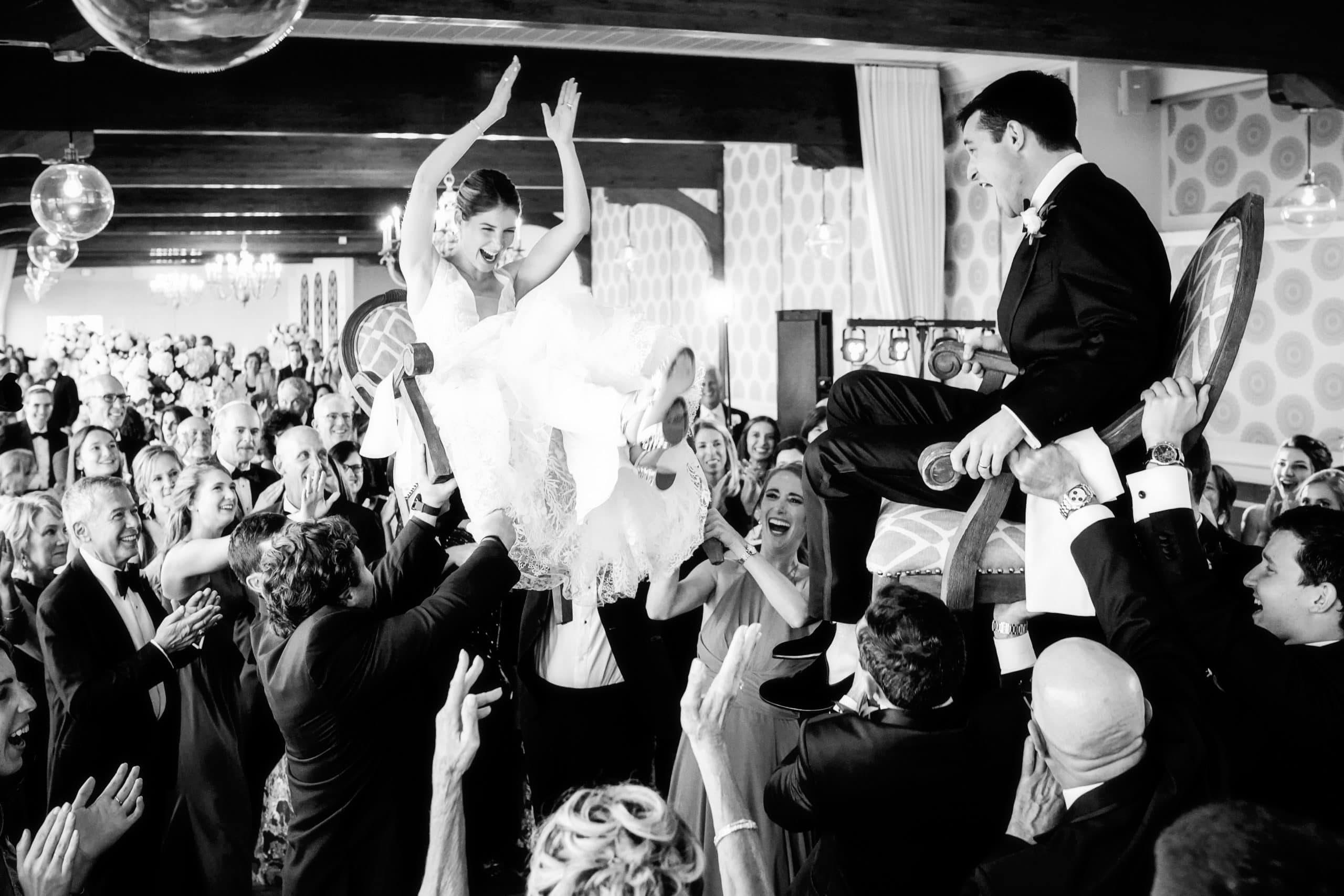 hora at a wychmere wedding on cape cod with happy bride and groom up on chairs